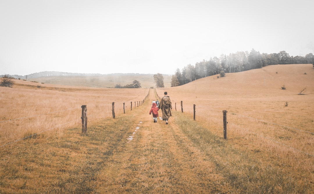 woman and child walking on grass field