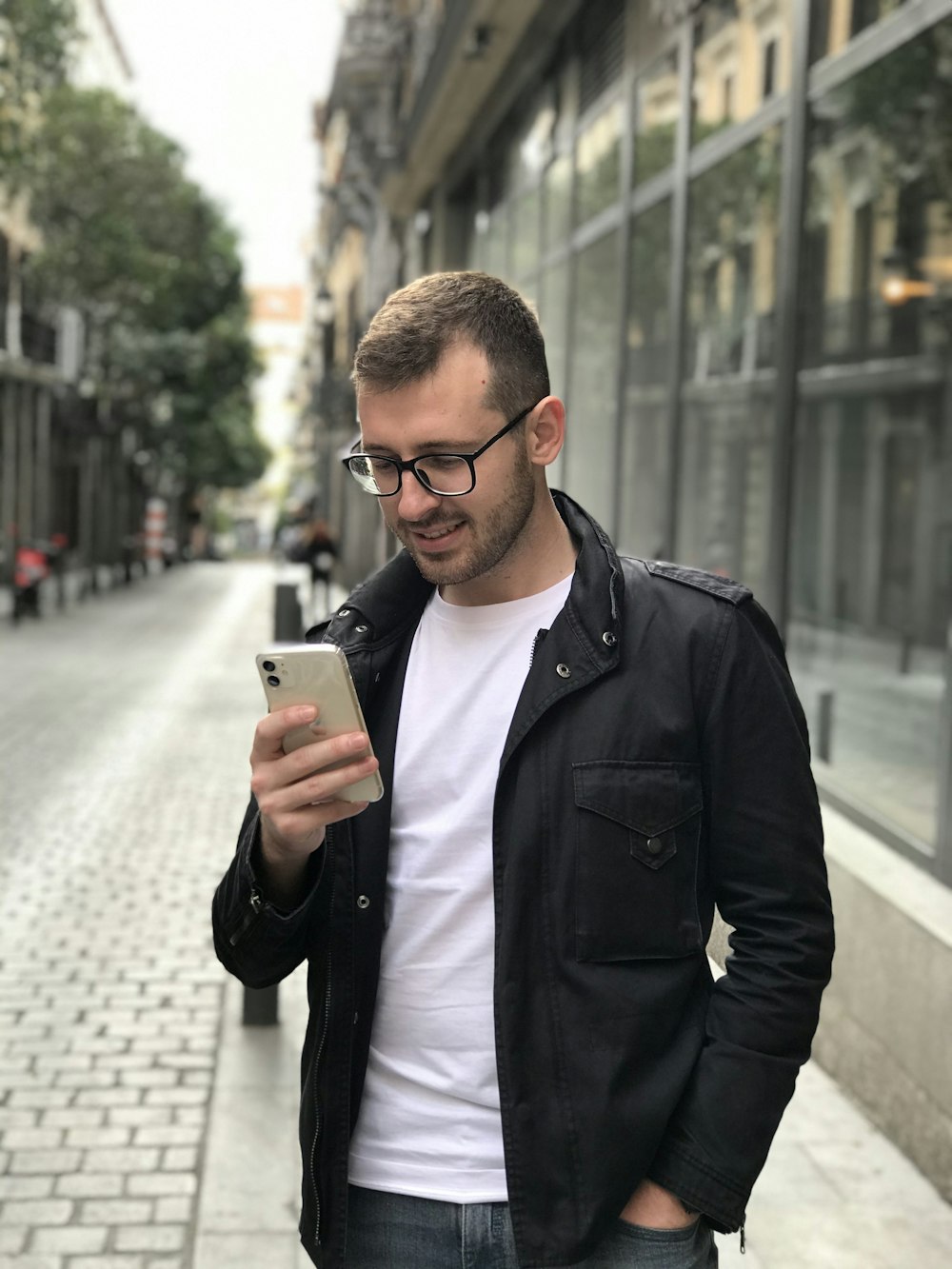 Veste zippée intégrale pour homme en noir à l’aide d’un smartphone