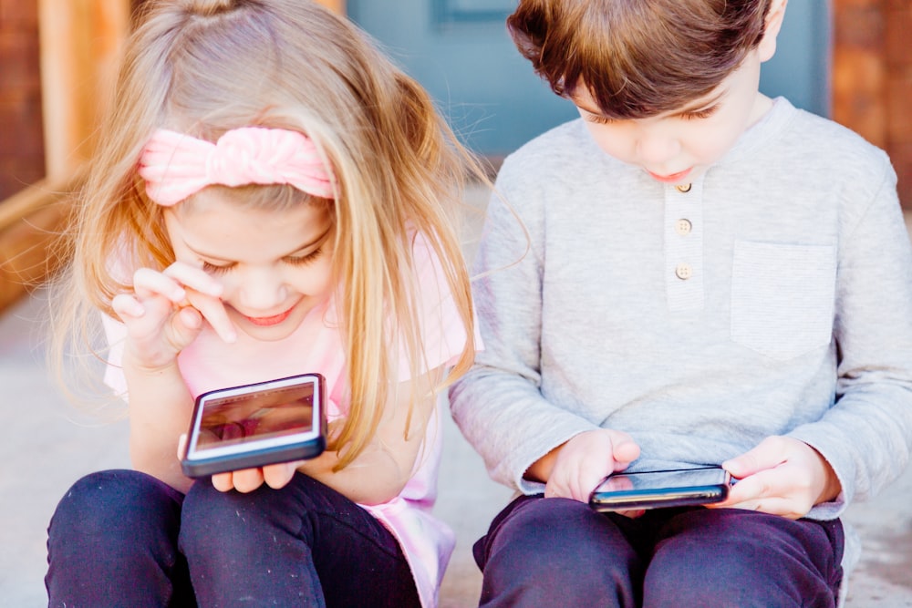 girl and boy using Android smartphones