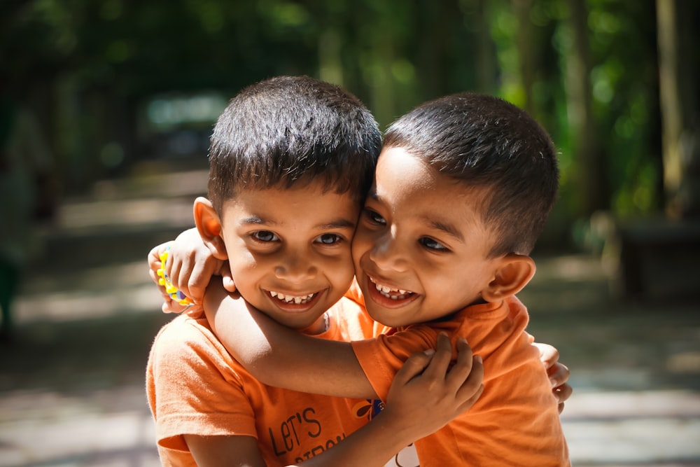 two boy's orange shirt