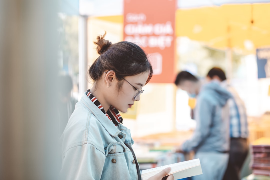 woman in blue denim jacket reading book