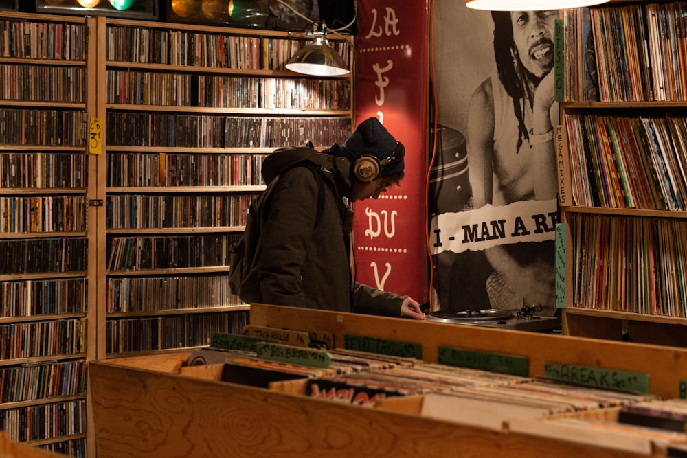 man in hoodie and headphones standing inside record store
