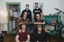 A diverse group of students laughing together in a spacious shared living room.