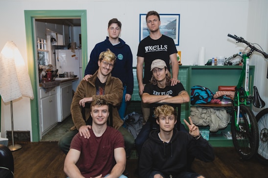 A diverse group of young adults smiling and chatting in a cozy living room.