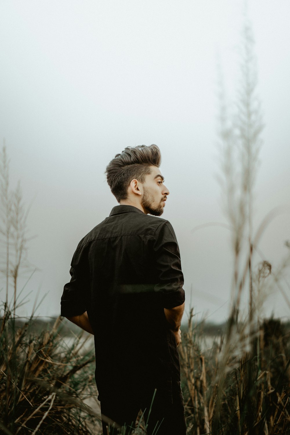 standing man standing on green grass during daytime