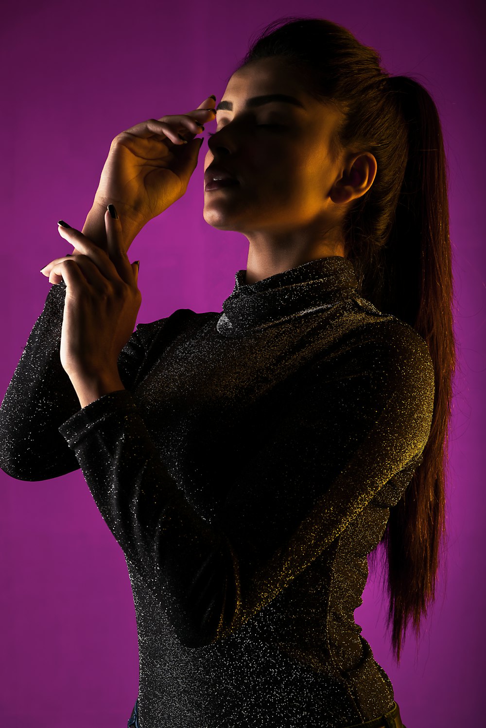 woman wearing gray turtleneck long-sleeved shirt standing while facing right side and closing her eyes