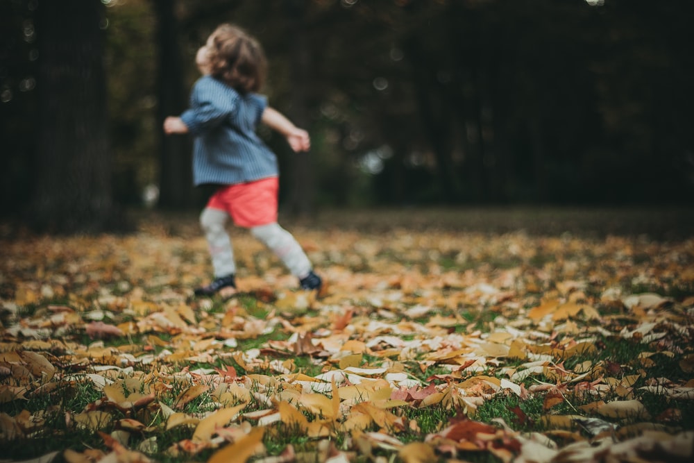 child running while looking up on green field