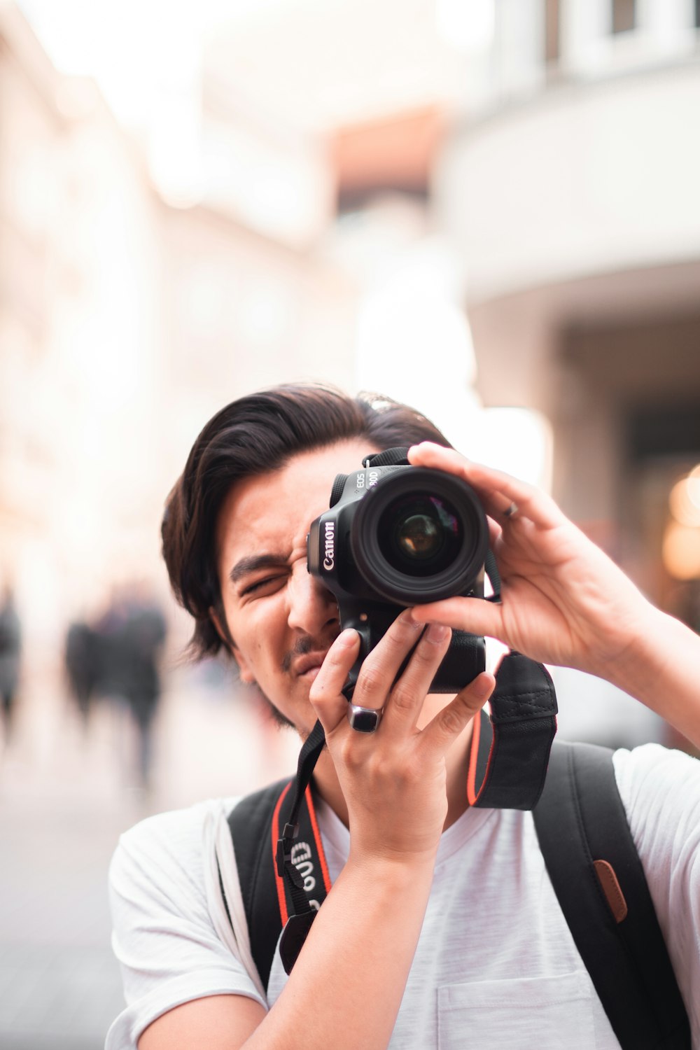 man taking photo using Canon DSLR camera