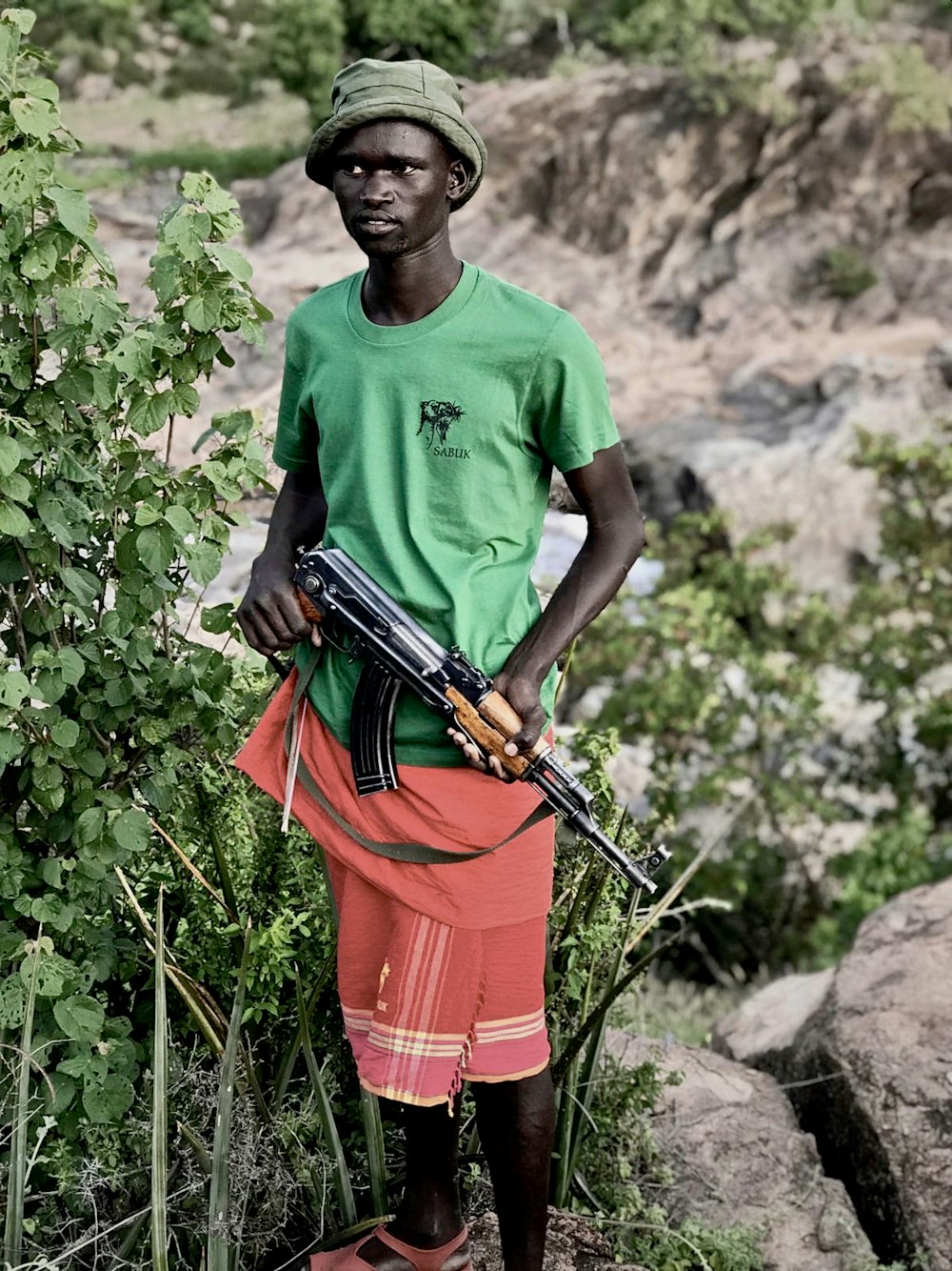 standing man holding AK-47