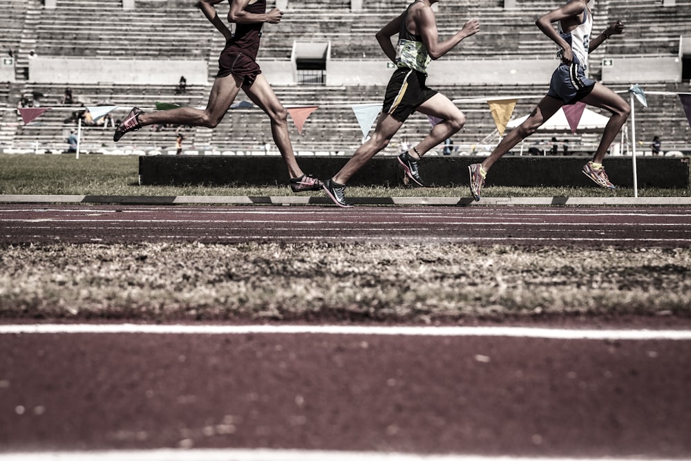 three running people on race tracks