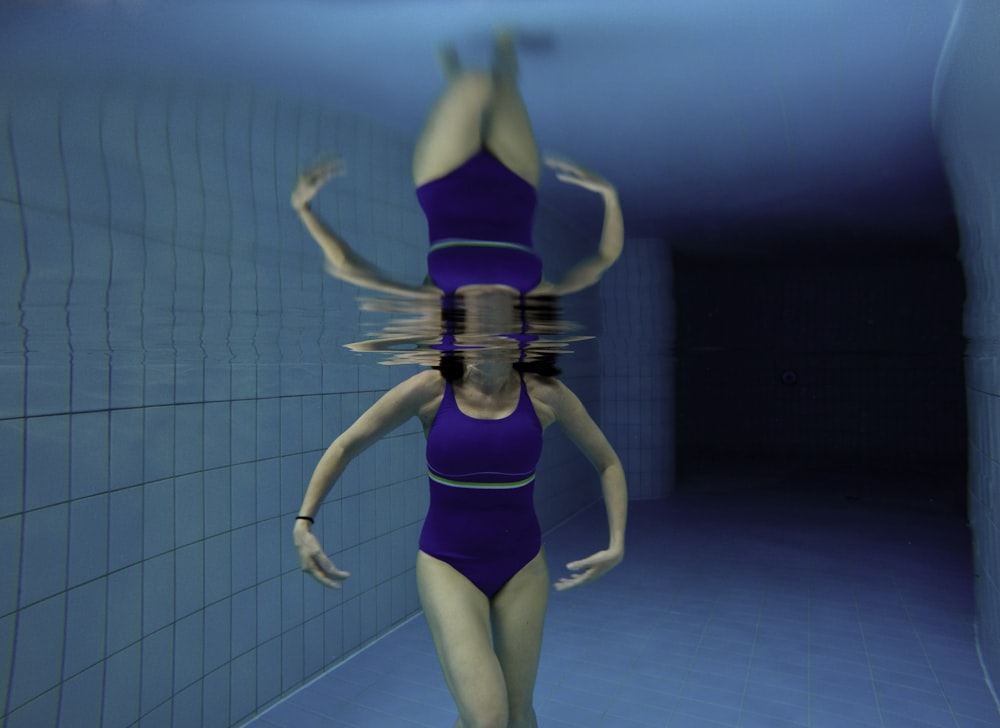 Fotografía bajo el agua de mujer con body azul