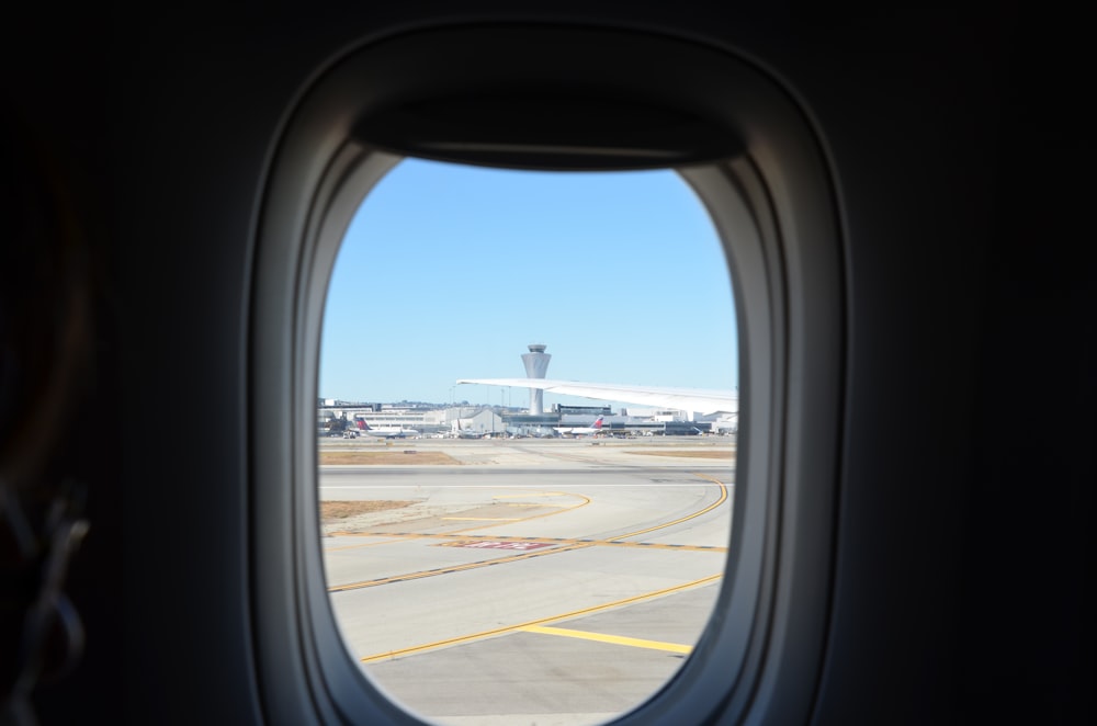 an airplane window with a view of an airport