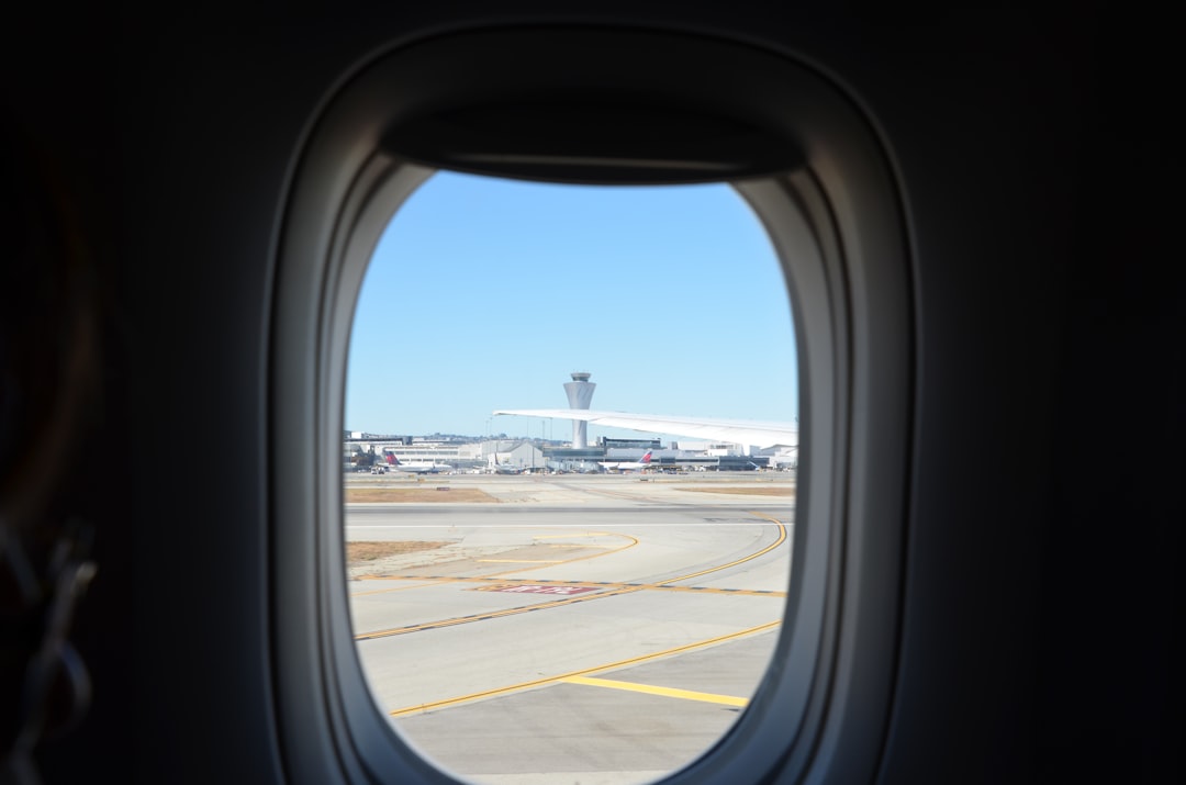 an airplane window with a view of an airport,