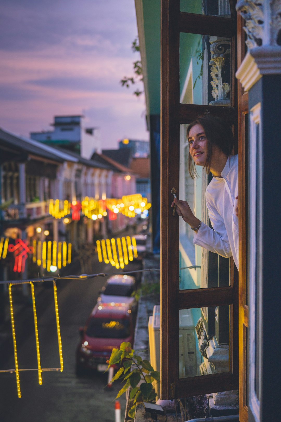 woman wearing white jacket opening window