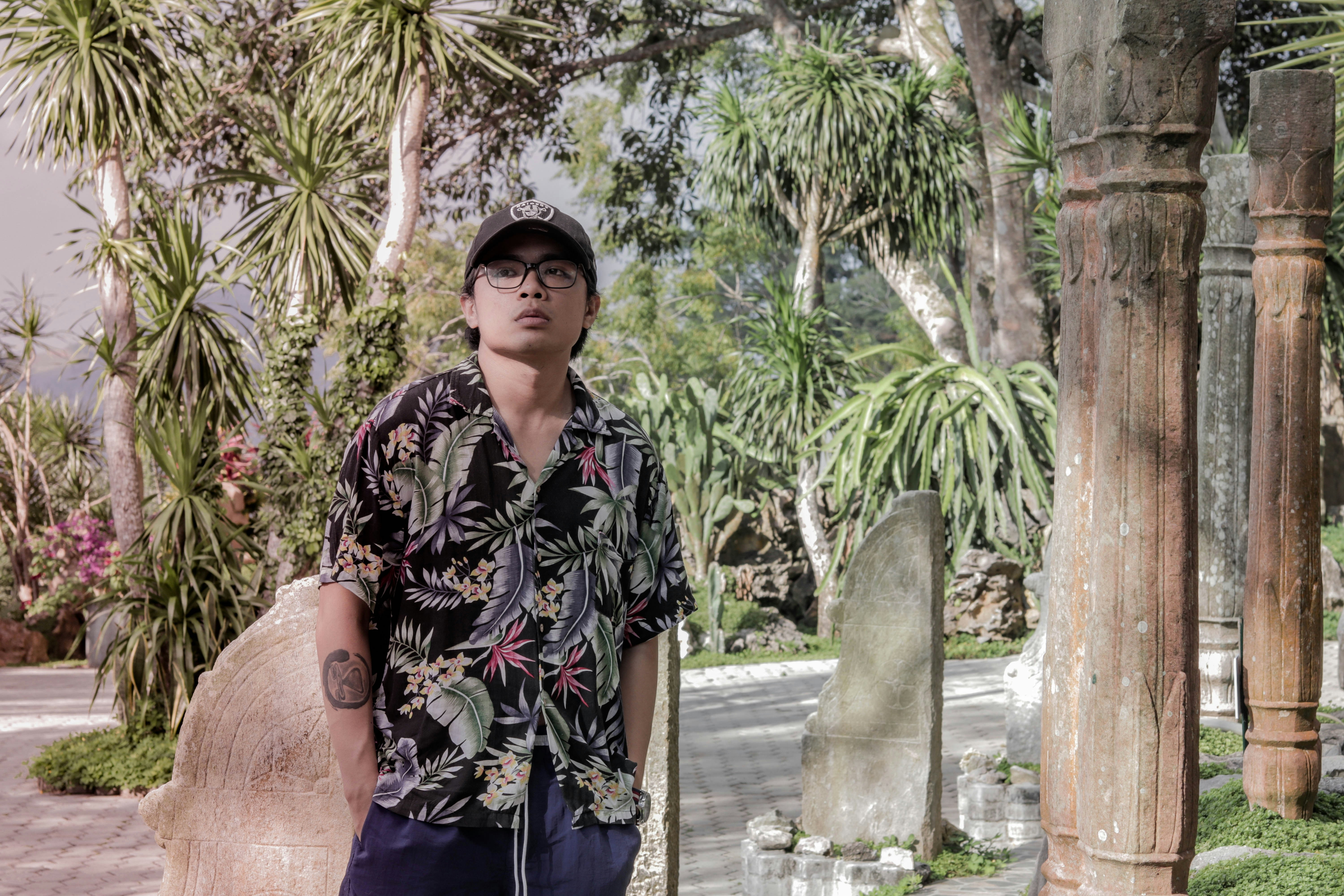 Seorang pria berdiri di samping patung batu