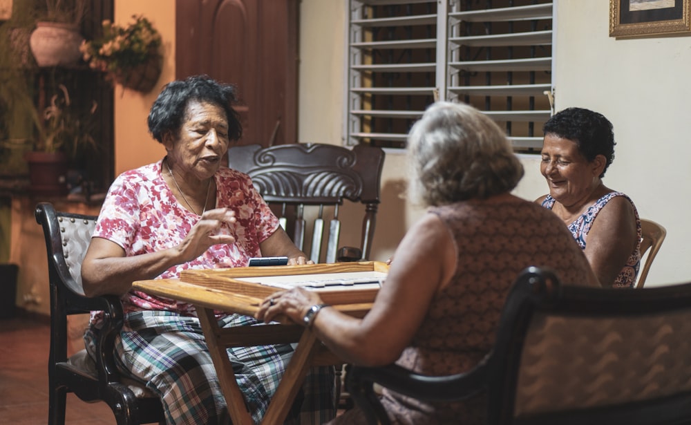 three women sitting in front of wooden table