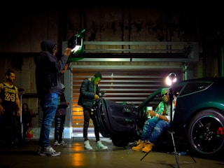 Behind-the-scenes moment of a photoshoot featuring vintage cars and influencers.