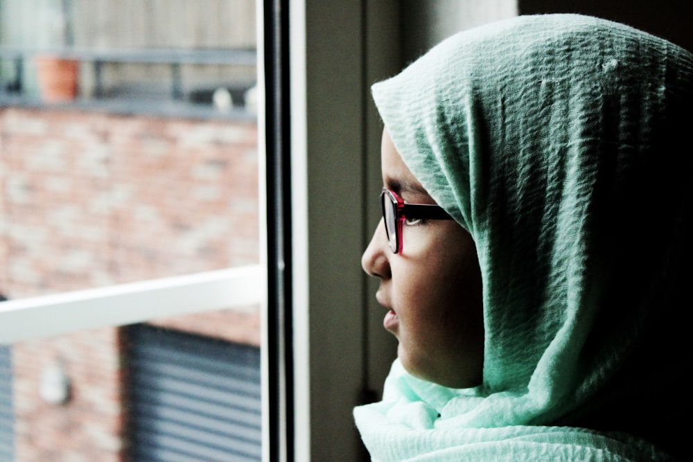 woman looking outside of the window during daytime