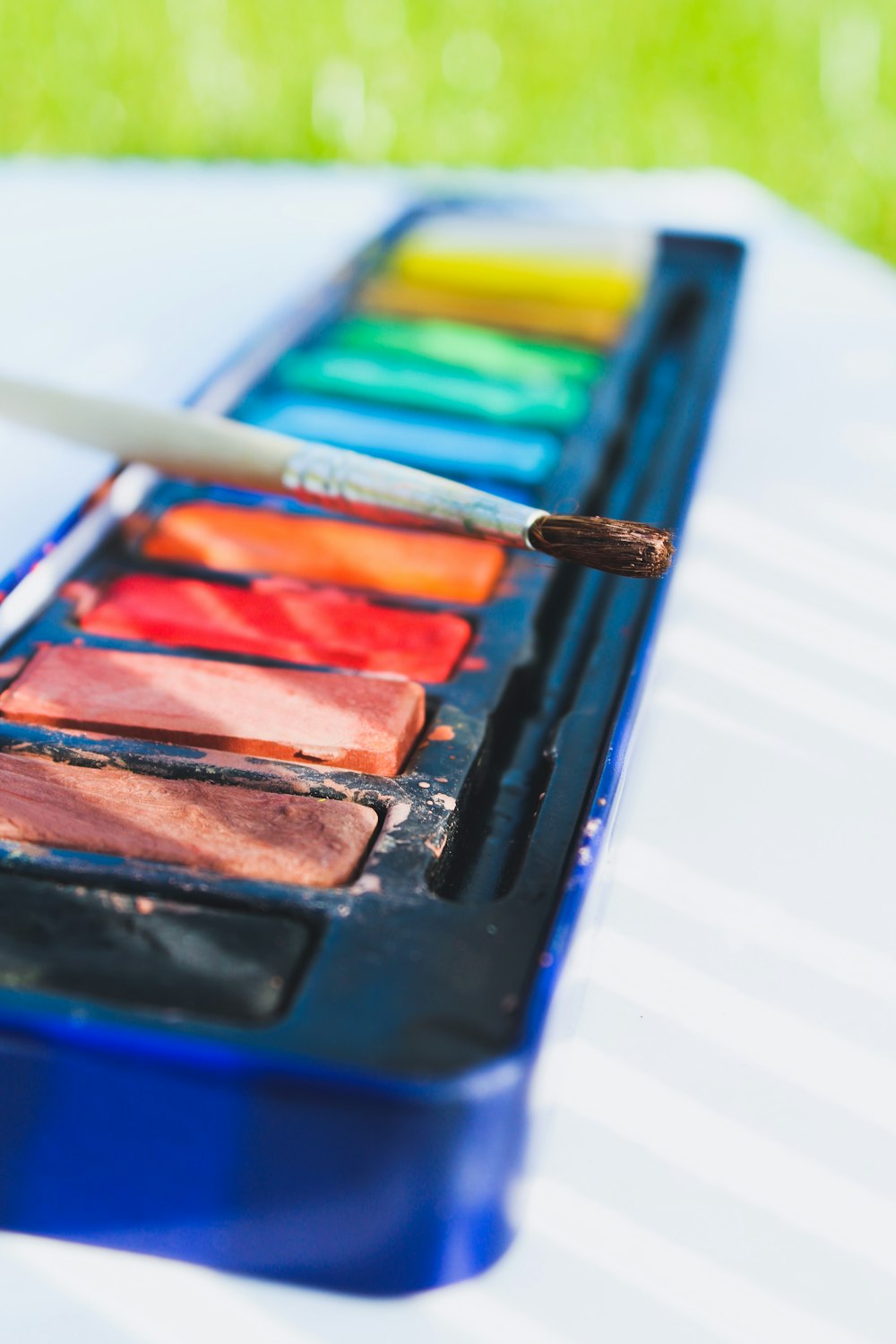 a close up of a paint palette with a brush