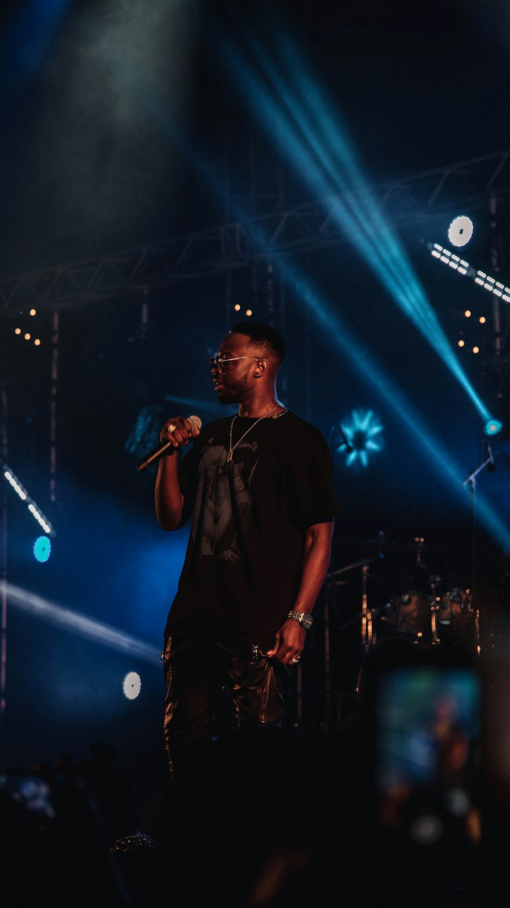 man in black shirt holding mic on stage