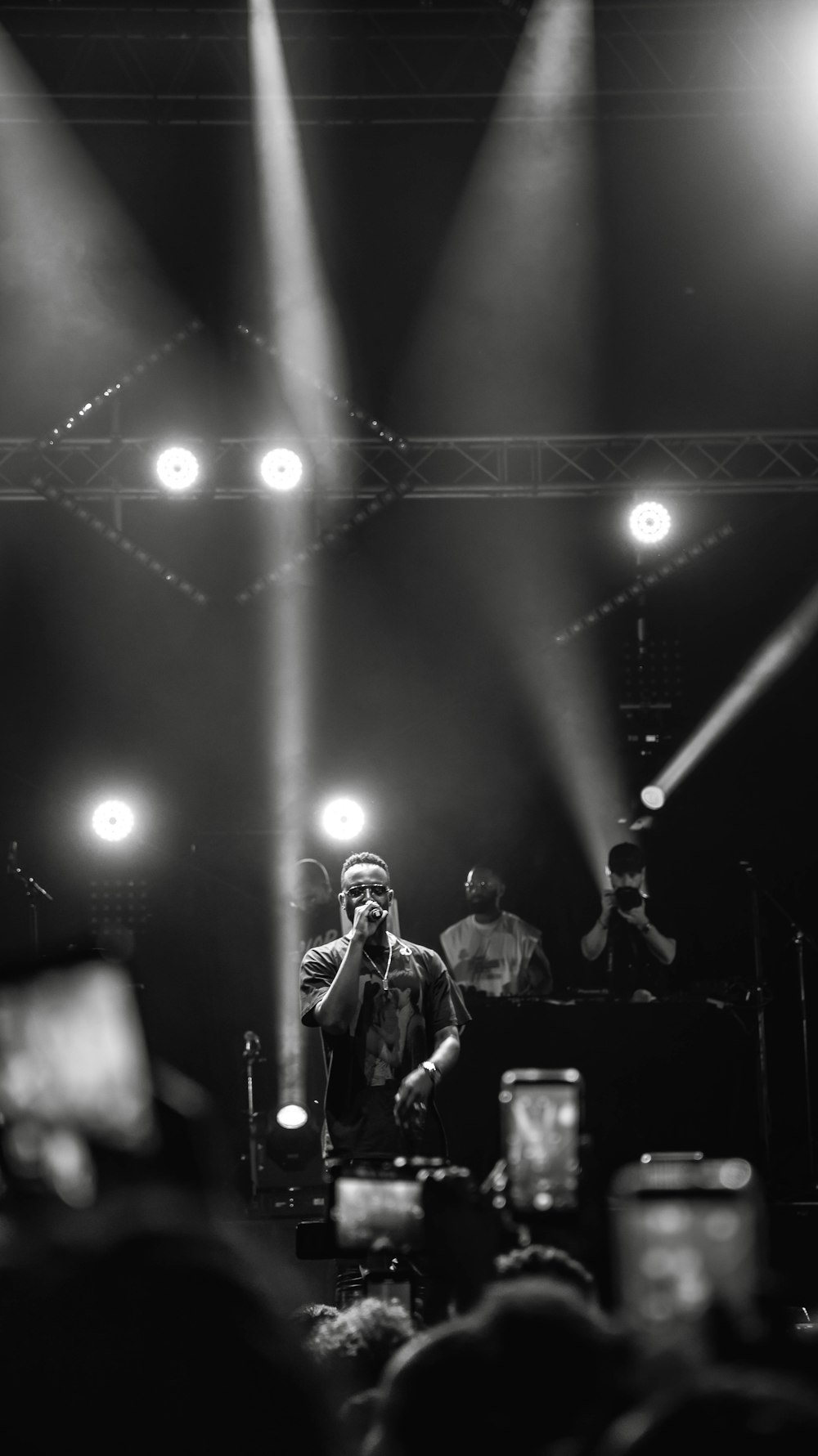 grayscale photography of man holding microphone on stage