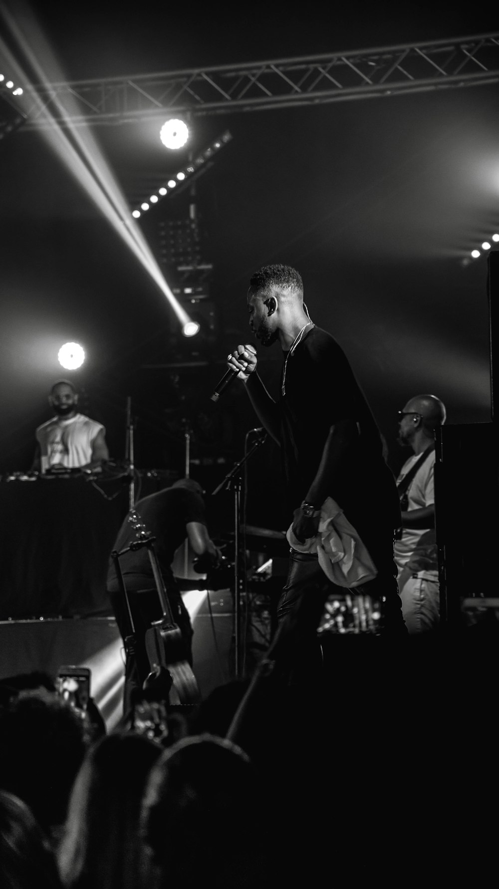 grayscale photo of man performing on stage