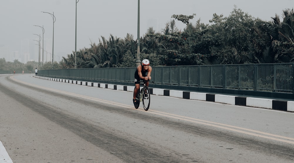 man wearing black tank top riding bicycle