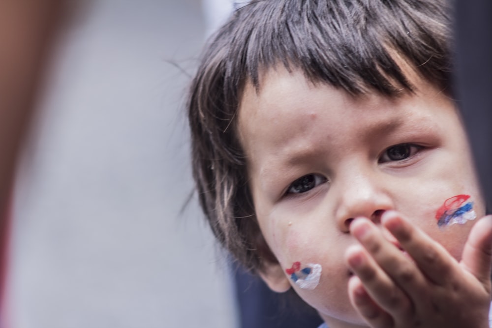 boy with red, blue, and white face art