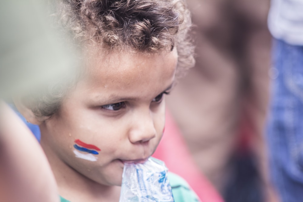 garçon avec un paquet transparent suspendu à sa bouche