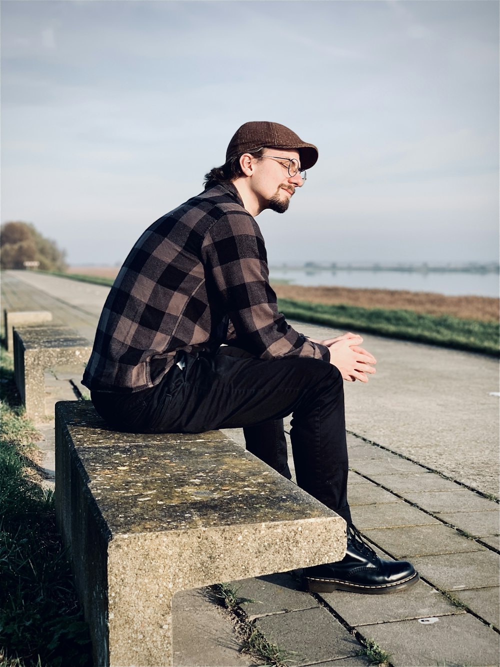 man sitting on bench on pier during day