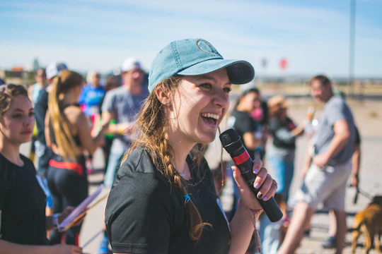 A smiling young woman speaking confidently at a community event.