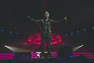 A moody stage shot of Nocturna performing under deep blue and purple lights.