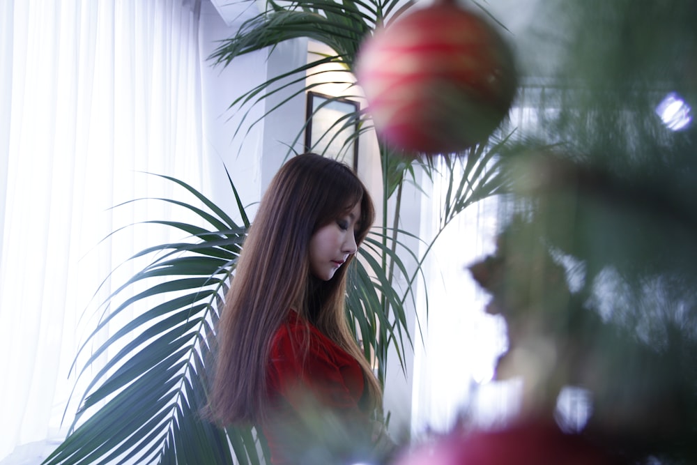 a woman standing in front of a christmas tree