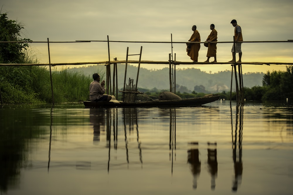 men walking across brown wooden bridge