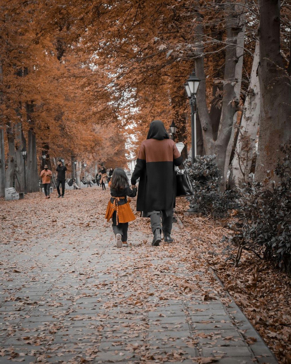 woman walking with her girl near the tree