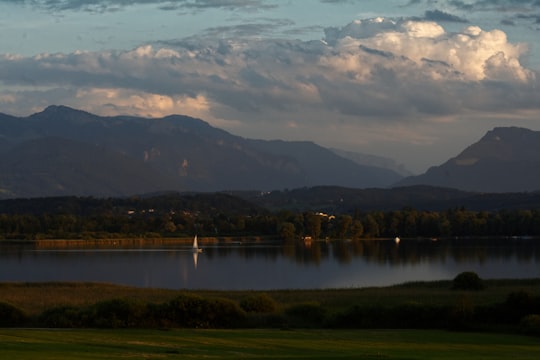 calm body of water overlooking mountain ridge in Chiemsee Germany