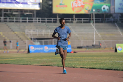Male athlete in action at an outdoor stadium wearing branded sports gear.