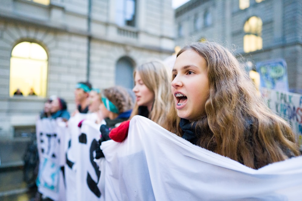 women carrying white banner