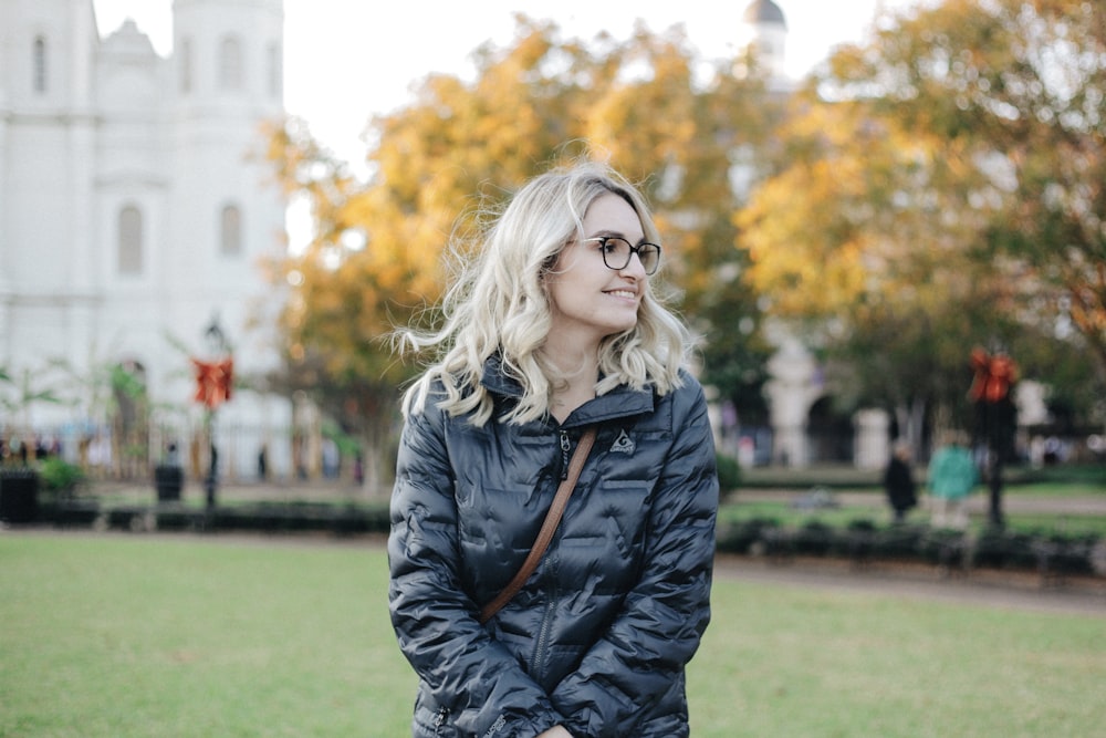 woman standing near cathedral beside trees during daytime