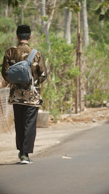 A quiet street scene with someone wearing a miga cap walking confidently.