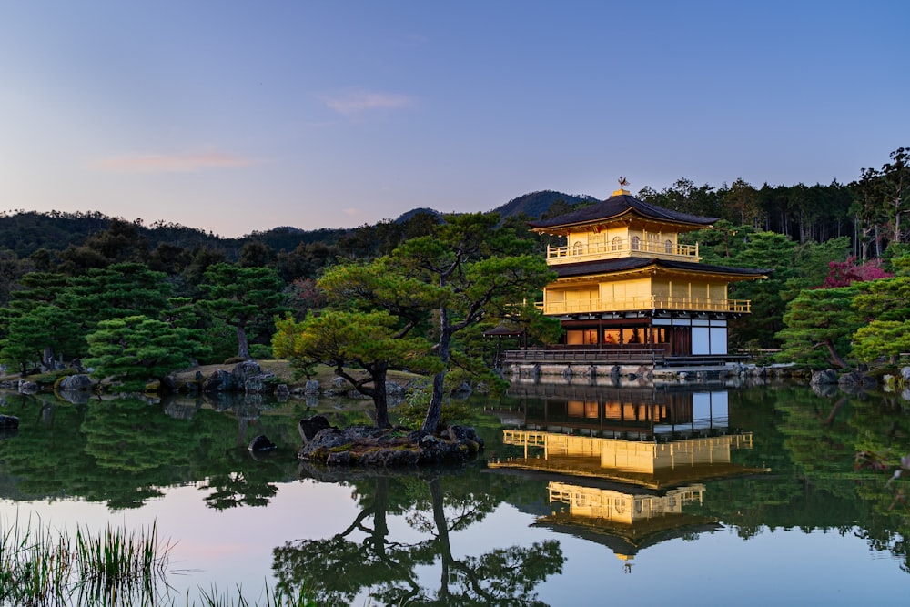 temple near trees and body of water during day