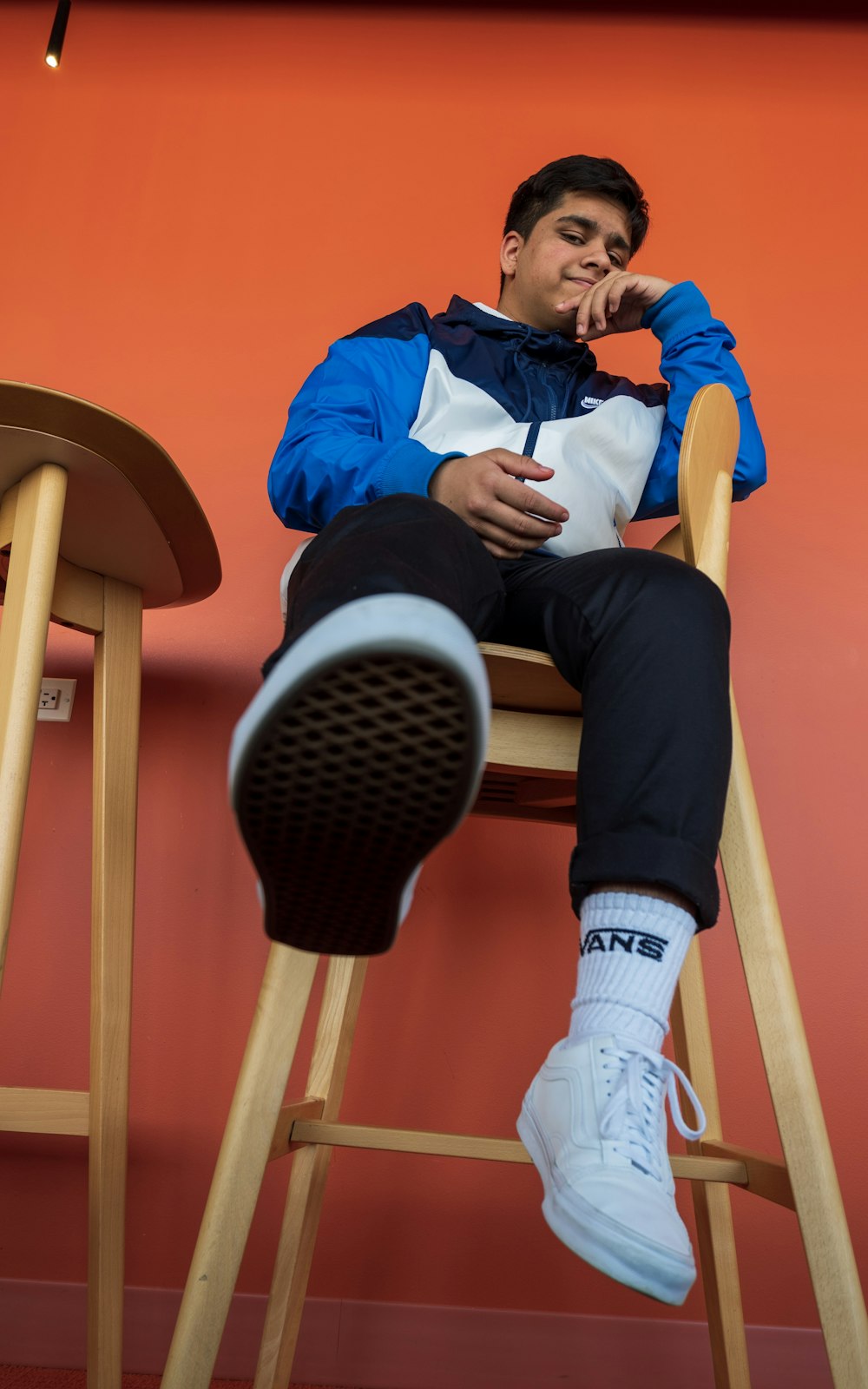 man sitting on brown wooden chair