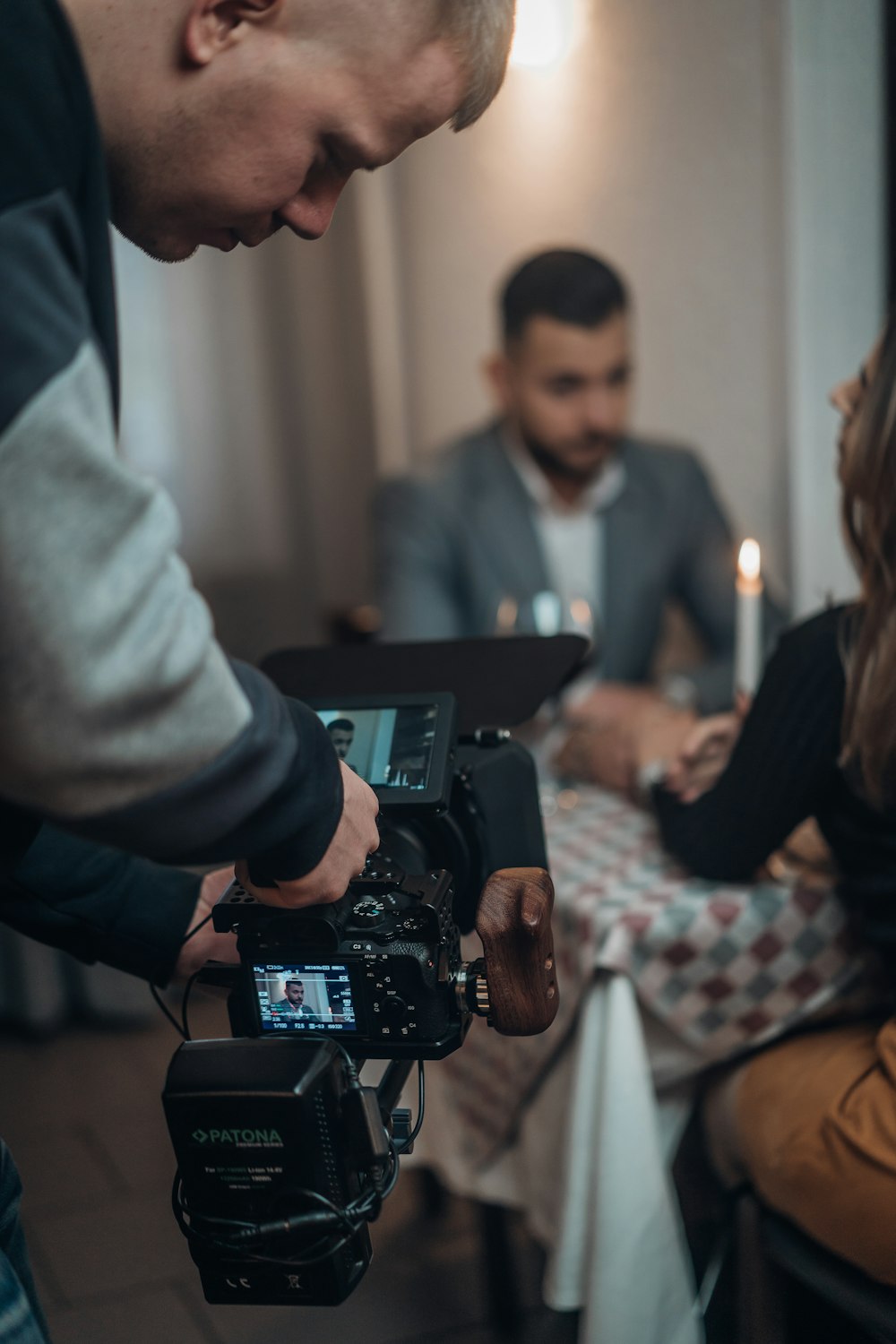 man taking video of man and woman