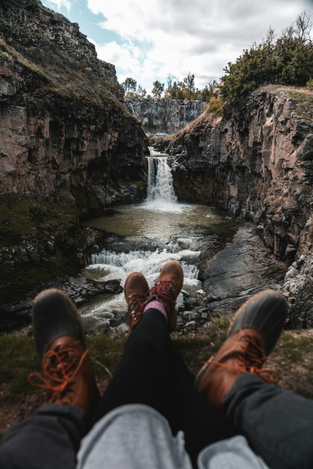 couple sitting on rock near river