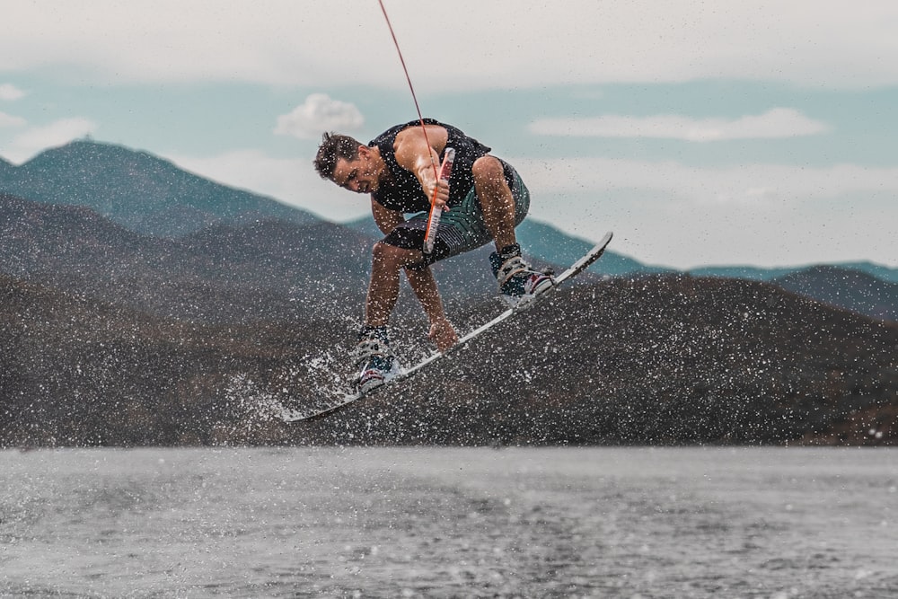 man in mid air riding wakeboard during day