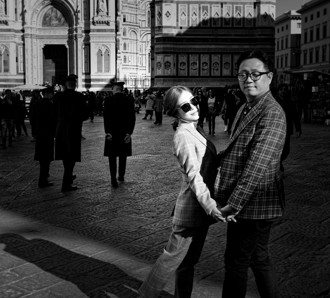 grayscale photo of people standing in front of building