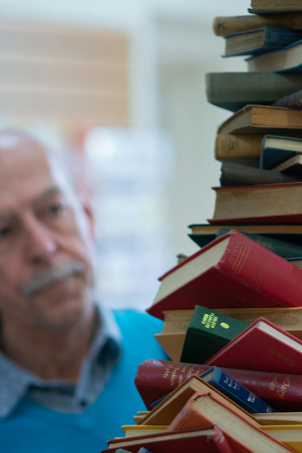 man facing pile of books