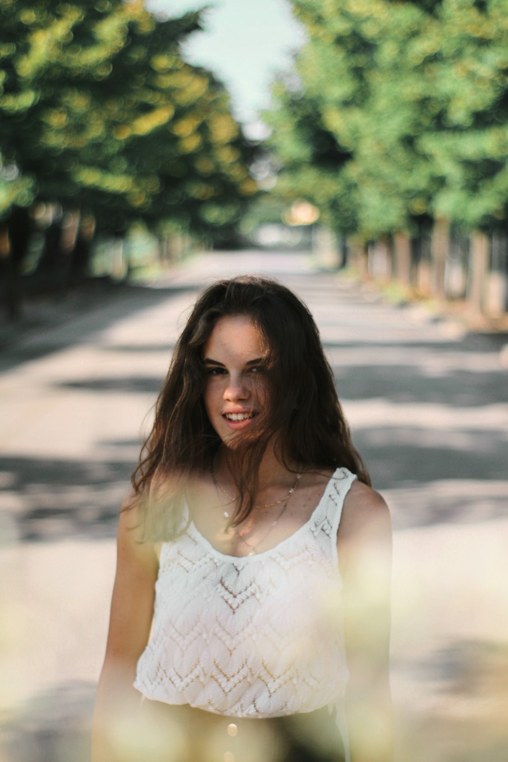 focus photography of woman standing in the middle of the road