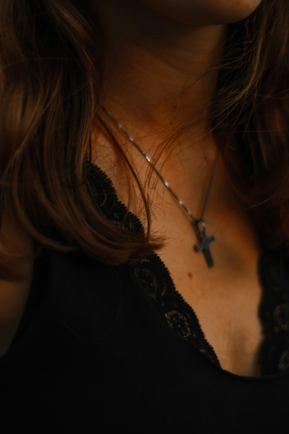 a close up of a woman wearing a cross necklace
