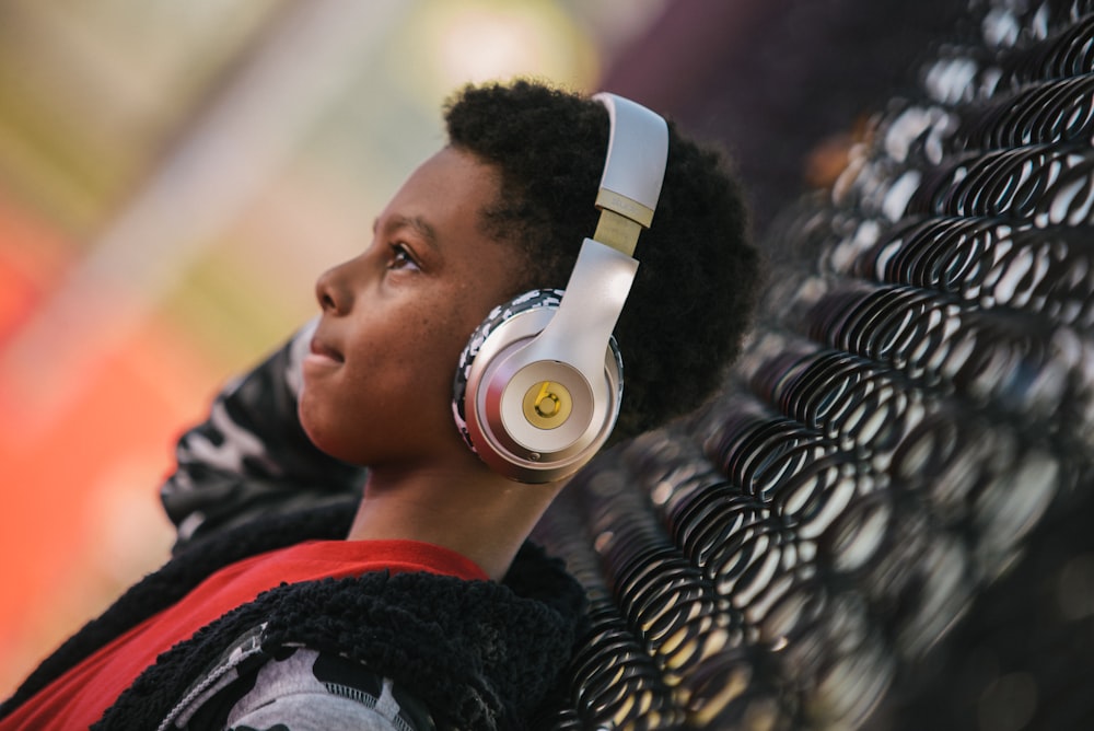 selective focus photo of boy wearing gold headphones